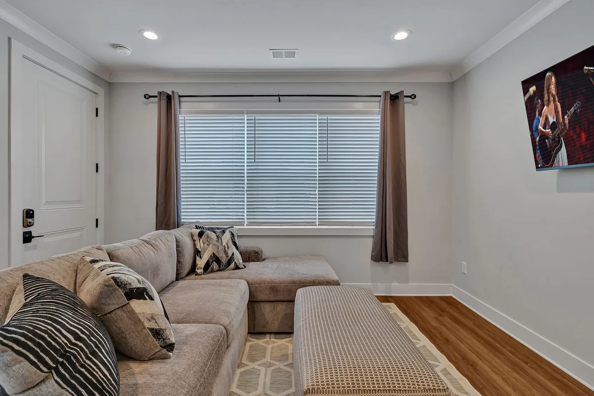 A large sectional sofa, accent pillows, and wall art define this comfortable and relaxed living space. The arrangement is ideal for socializing, relaxing, or enjoying a movie night, with ample room for all guests and even pets.