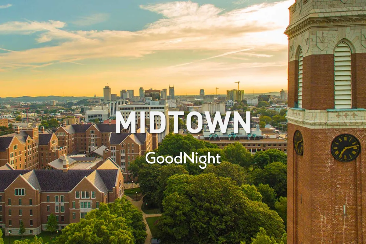 A peaceful cityscape view with a skyline, historic buildings, a prominent clock tower, and lush green trees in the foreground. The evening light creates a serene atmosphere, ideal for reflective moments or quiet appreciation of the city's beauty from a rooftop vantage point.